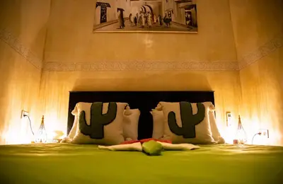 a bedroom with a bed with green sheets and pillows at RIAD Dar ZOMOROD in Marrakech