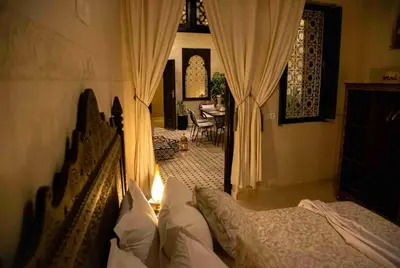 a bedroom with a bed and a room with a table at RIAD Dar ZOMOROD in Marrakech