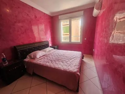 a bedroom with a bed with pink walls and a window at Charme & Confort -2 Chambres-Wifi-Azar in Marrakech