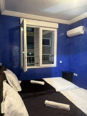 a blue room with two beds and a window at Charme & Confort -2 Chambres-Wifi-Azar in Marrakech