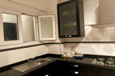 a small kitchen with a sink and two windows at Charme & Confort -2 Chambres-Wifi-Azar in Marrakech