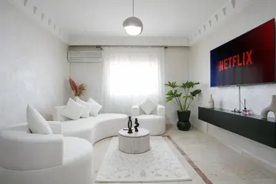 a living room with white furniture and a tv at La Perle Blanche Gueliz in Marrakech