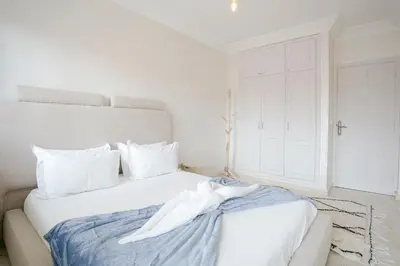 a white bed with a white robe on it at La Perle Blanche Gueliz in Marrakech