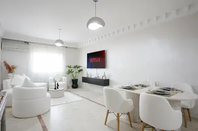 a white living room with a table and white chairs at La Perle Blanche Gueliz in Marrakech