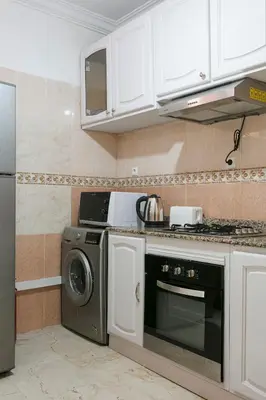 a kitchen with a stove and a dishwasher at La Perle Blanche Gueliz in Marrakech