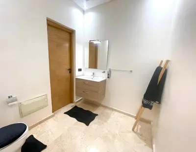 a bathroom with a sink and a toilet and a mirror at Villa avec piscine privée et sans vis à vis à Marrakech in Douar Nouaji