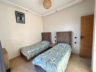 a bedroom with two beds and a door at Villa avec piscine privée et sans vis à vis à Marrakech in Douar Nouaji