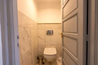 a small bathroom with a toilet and a door at Luxury Oasis 2 Bedroom and Free Parking in Hivernage in Marrakech