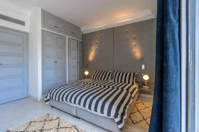 a bedroom with a bed with a black and white striped comforter at Luxury Oasis 2 Bedroom and Free Parking in Hivernage in Marrakech