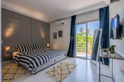 a bedroom with a bed and a large window at Luxury Oasis 2 Bedroom and Free Parking in Hivernage in Marrakech