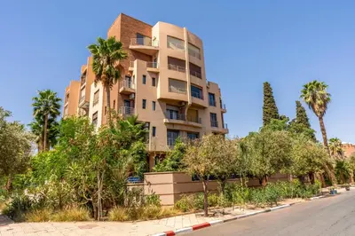an apartment building with palm trees on the side of a street at Luxury Oasis 2 Bedroom and Free Parking in Hivernage in Marrakech