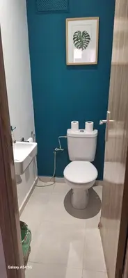 a blue bathroom with a toilet and a sink at Appartement moderne rénové in Marrakech