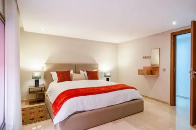 a bedroom with a large bed with a red blanket at Stayin 3Bedroom Duplex in Marrakech