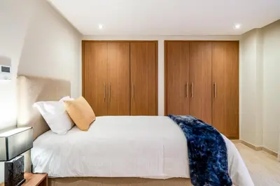 a bedroom with wooden cabinets and a white bed at Stayin 3Bedroom Duplex in Marrakech