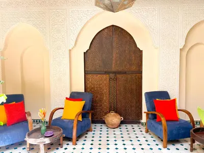 a room with two chairs and a table with colorful pillows at Riad Kech One & Spa in Marrakech