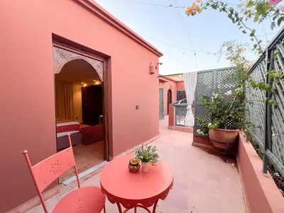 a patio with a red table and chairs on a balcony at Riad Kech One & Spa in Marrakech