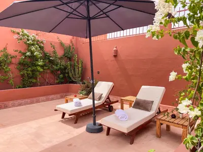 two chairs and an umbrella on a patio at Riad Kech One & Spa in Marrakech