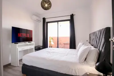 a bedroom with a bed with a television and a window at A Stay To Remember - Marrakech Downtown in Marrakech