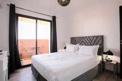a bedroom with a bed and a large window at A Stay To Remember - Marrakech Downtown in Marrakech