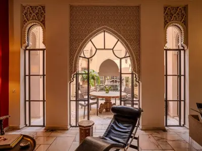 a living room with an archway and a table with chairs at Riad Mayan & Spa in Marrakech