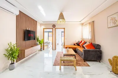 a living room with a couch and a tv at Luxe et Calme de Guéliz avec Grande Terrasse in Marrakech