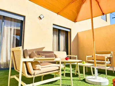 a patio with a table and chairs and an umbrella at Luxe et Calme de Guéliz avec Grande Terrasse in Marrakech