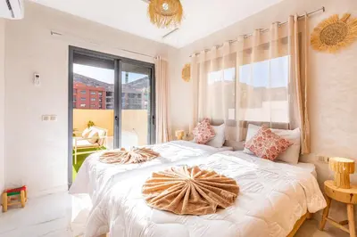 a bedroom with a large white bed with a large window at Luxe et Calme de Guéliz avec Grande Terrasse in Marrakech