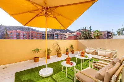a patio with two tables and an umbrella at Luxe et Calme de Guéliz avec Grande Terrasse in Marrakech