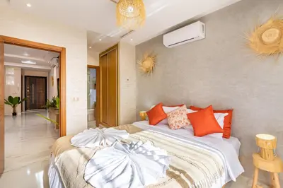 a bedroom with a large bed with orange pillows at Luxe et Calme de Guéliz avec Grande Terrasse in Marrakech