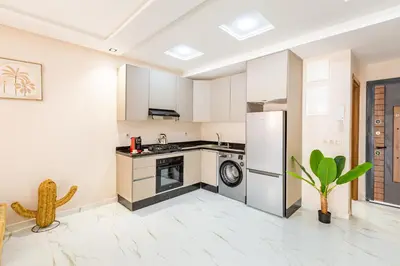 a kitchen with a stove and a refrigerator at Luxe et Calme de Guéliz avec Grande Terrasse in Marrakech