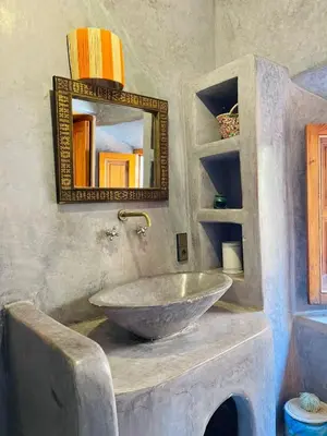a bathroom with a bowl sink and a mirror at Riad Numidia in Marrakech