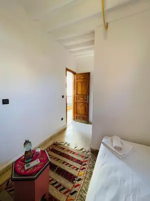 a bedroom with a bed and a room with a door at Riad Numidia in Marrakech