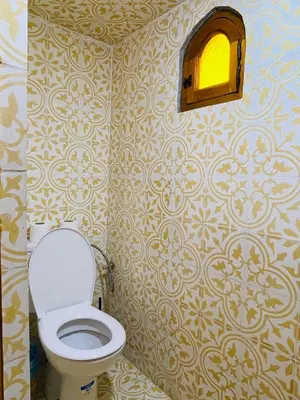 a bathroom with a toilet and a window in it at Riad Numidia in Marrakech