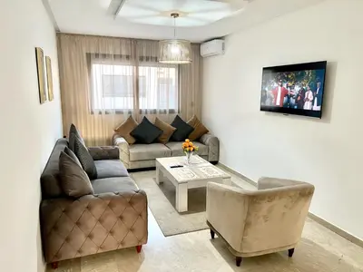 a living room with a couch and a table at Appartement à louer in Marrakech