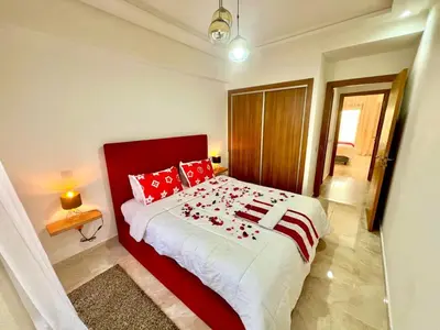 a bedroom with a large bed with red pillows at Appartement à louer in Marrakech