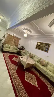 a living room with a green couch and a red rug at Marrakech héberg in Marrakech