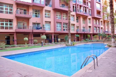 a swimming pool in front of a pink building at M17-Le Duplex-Balcon-Piscine-Majorelle in Marrakech