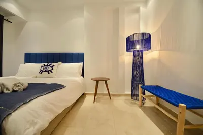 a bedroom with a bed and a lamp and a bench at M17-Le Duplex-Balcon-Piscine-Majorelle in Marrakech