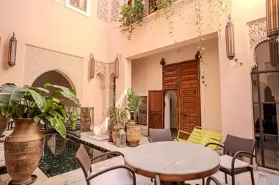 a patio with a table and chairs in a building at Riad MAYAN Heated Pool and GYM in Marrakech