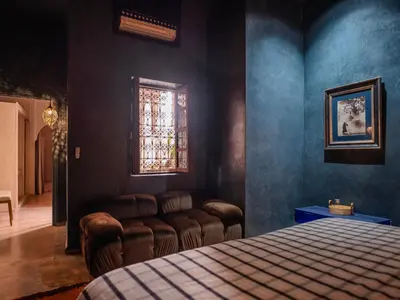 a bedroom with a bed and a couch and a window at Riad MAYAN Heated Pool and GYM in Marrakech