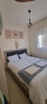 a bedroom with a large bed with white sheets and pillows at Cozy appartement à Marrakesh in Marrakech