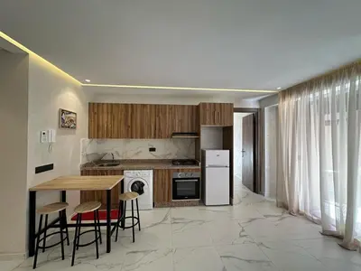 a kitchen with a table and chairs and a refrigerator at Spacieux Appartement avec terrasse coeur de Marrakech in Marrakech