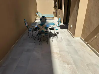 a table and chairs sitting on a tile floor at Spacieux Appartement avec terrasse coeur de Marrakech in Marrakech
