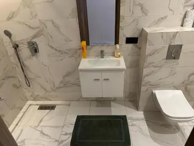 a white bathroom with a sink and a toilet at Spacieux Appartement avec terrasse coeur de Marrakech in Marrakech