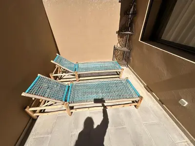 a shadow of a person taking a picture of two lounge chairs at Spacieux Appartement avec terrasse coeur de Marrakech in Marrakech