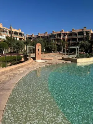 a large swimming pool in front of a building at charmant appartement avec grande piscine & terrasse in Marrakech