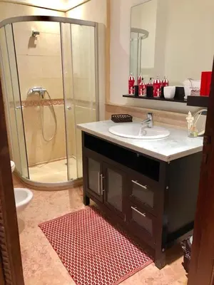 a bathroom with a shower and a sink and a sink at charmant appartement avec grande piscine & terrasse in Marrakech