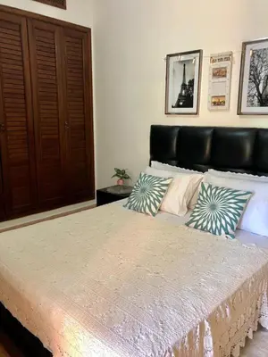a bedroom with a large bed with pillows on it at charmant appartement avec grande piscine & terrasse in Marrakech