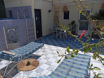 a patio with blue tiles and chairs and a table at appartement 6 min centre terrasse in Marrakech