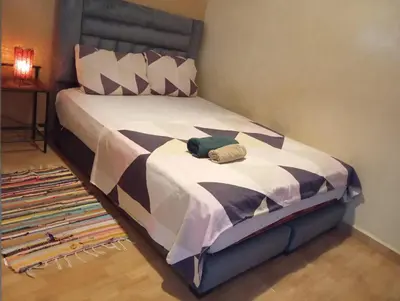 a bed with a black and white comforter at appartement 6 min centre terrasse in Marrakech